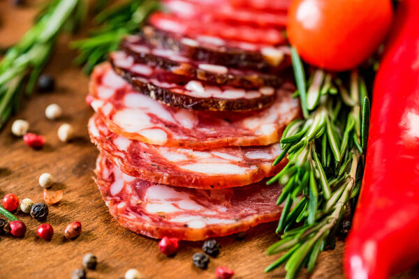 Three sorts of salami with tomatoes and peppercorn