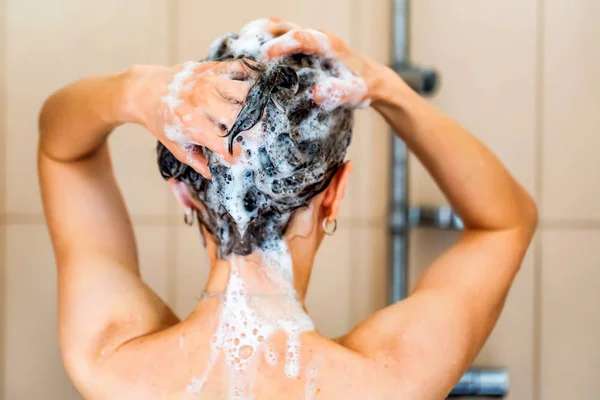 Back view oung woman washing head with shampoo — Stock Photo, Image