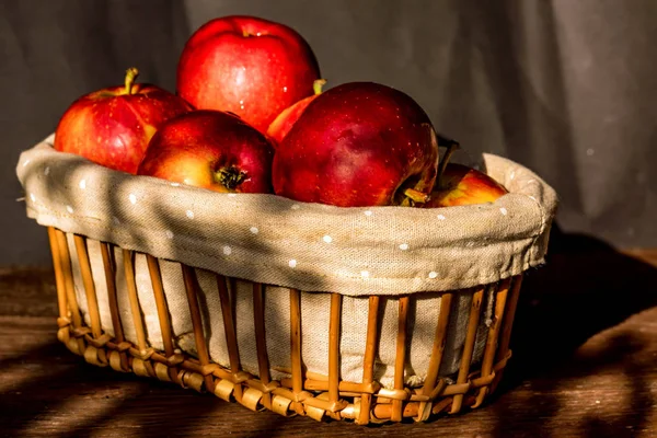 Röda saftiga äpplen i korg nära — Stockfoto