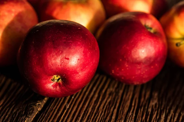 Manzanas rojas maduras enteras en superficie de madera cerrar — Foto de Stock