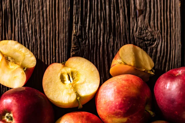 Fondo de manzanas enteras y cortadas en madera — Foto de Stock