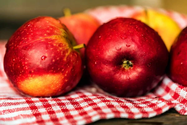 Zcela zralá červená jablka na zaškrtnutých ubrus zavřít — Stock fotografie