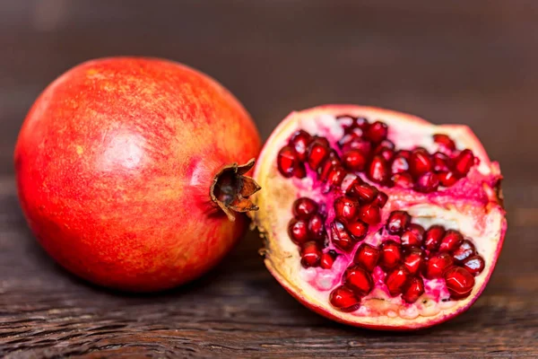 Ripe pomegranate fruits on wooden background — Stock Photo, Image