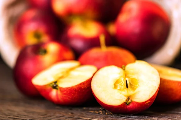 Pommes entières et coupées en deux sur la surface en bois — Photo