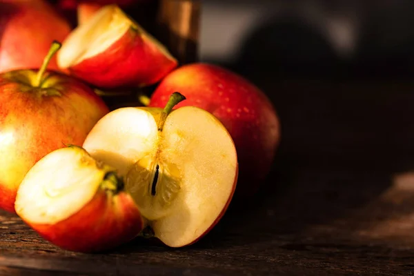 Pommes entières et coupées en deux sur la surface en bois — Photo
