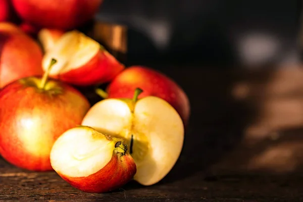 Całe jabłka i pokroić w połowy powierzchni drewnianych — Zdjęcie stockowe