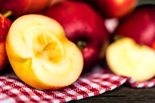 Kırmızı elma tüm ve kesim ekose desenli masa örtüsü üzerinde — Stok fotoğraf
