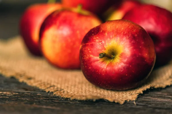 Whole ripe red apples on burlap napkin close — Stock Photo, Image
