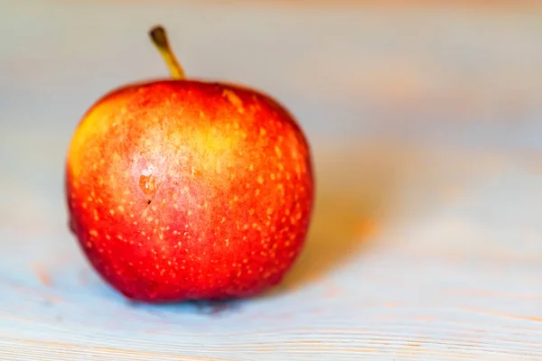 Całe, świeże, Czerwone jabłko na niebieski powierzchni drewnianych — Zdjęcie stockowe