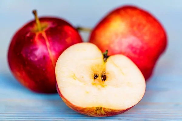 Appels hele en geknipte op blauwe houten oppervlak — Stockfoto