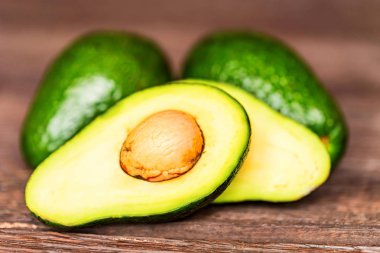 Avokado kesilmiş ve tüm ahşap arka plan üzerinde