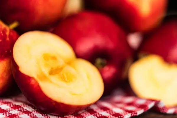 Kırmızı elma tüm ve kesim ekose desenli masa örtüsü üzerinde — Stok fotoğraf