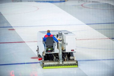 Resurfacing machine cleans ice of hockey rink clipart