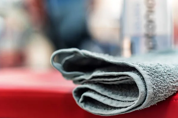 Grey towel lies on red surface in gym — Stock Photo, Image