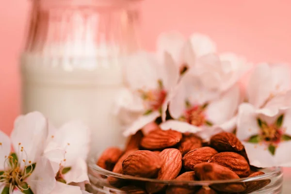 Almendra con tarro de leche de almendras y flores blancas —  Fotos de Stock