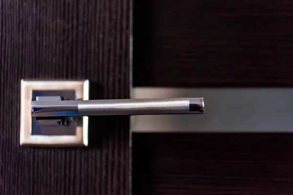 Gagang pintu logam modern pada pintu kayu gelap — Stok Foto
