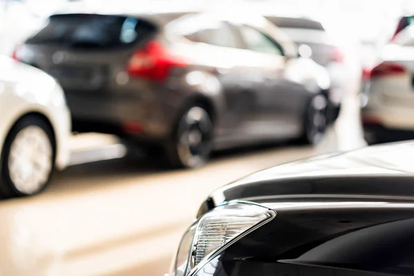 Nuevos coches en la sala de exposición distribuidor fondo borroso — Foto de Stock