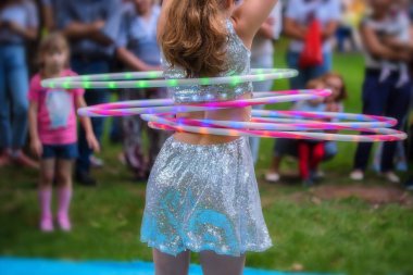 Güzel elbiseli kız hula hoops ile gerçekleştirir