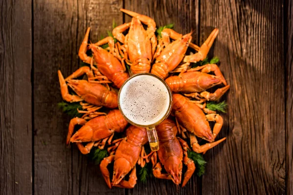 Boiled crayfish with beer on wooden background