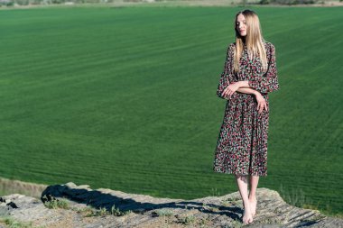 Kaya doğada elbiseli güzel kız poz veriyor