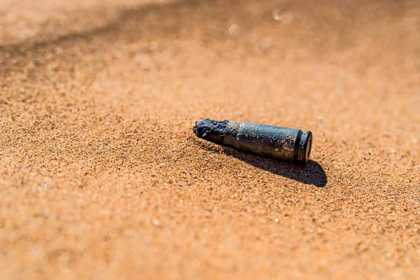 Estuche viejo cartucho oxidado en arena cerrar — Foto de Stock