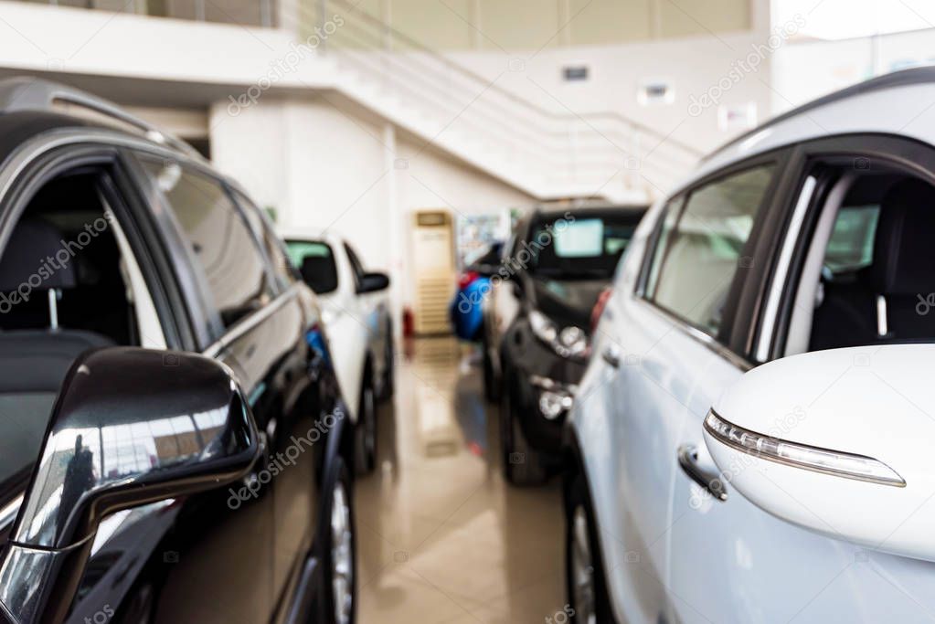 New cars at dealer showroom blurred background