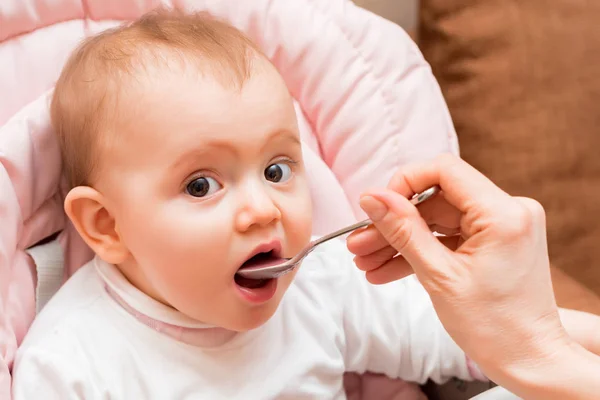 Niña pequeña mientras es alimentada con la boca abierta —  Fotos de Stock