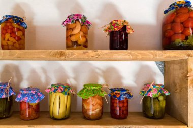 Cam kavanozlarda renkli sebzeler ve mantarlar.