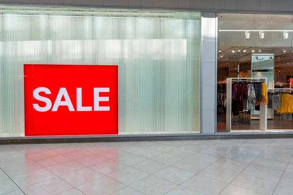 Sinal de venda vermelho na entrada da loja de roupas — Fotografia de Stock