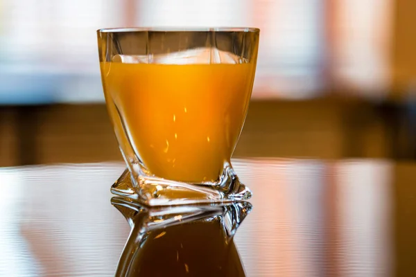 木のテーブルの近くに新鮮なオレンジジュースのガラス — ストック写真