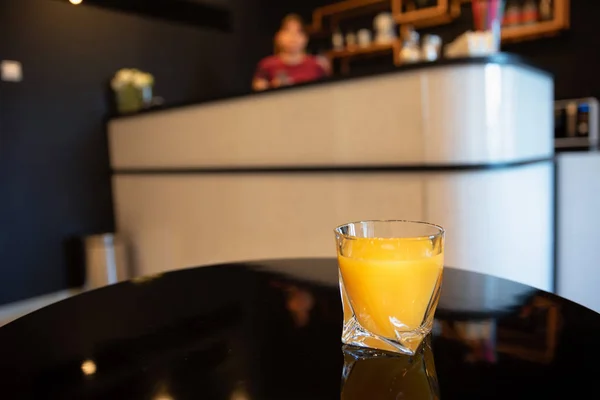 Un vaso de jugo de naranja fresco en una mesa de madera en el bar — Foto de Stock