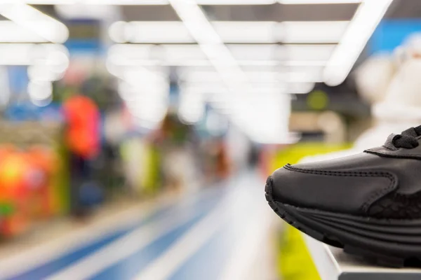 Fechar acima do sapato de esportes na loja com fundo borrado — Fotografia de Stock