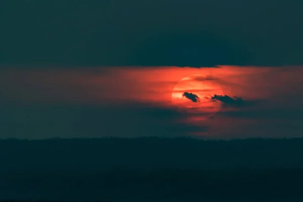 Céu de pôr-do-sol dramático com nuvens escuras e sol vermelho — Fotografia de Stock