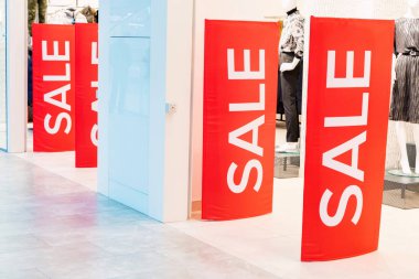 Elbise mağazasının girişinde kırmızı satış tabelaları