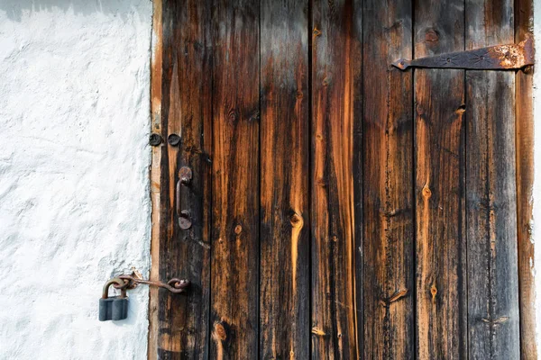 Feche a velha porta de madeira com dobradiças enferrujadas — Fotografia de Stock