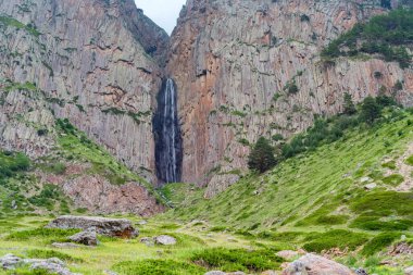 İki kayanın arasında dağ şelalesi olan yaz manzarası