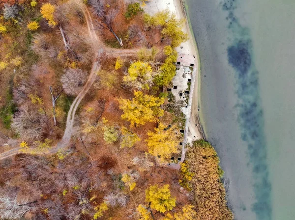 Ovanifrån gamla övergivna betongfartyg på hösten flodstrand — Stockfoto