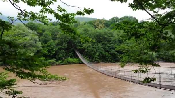 Flight over suspension bridge and mountain river — Stock Video