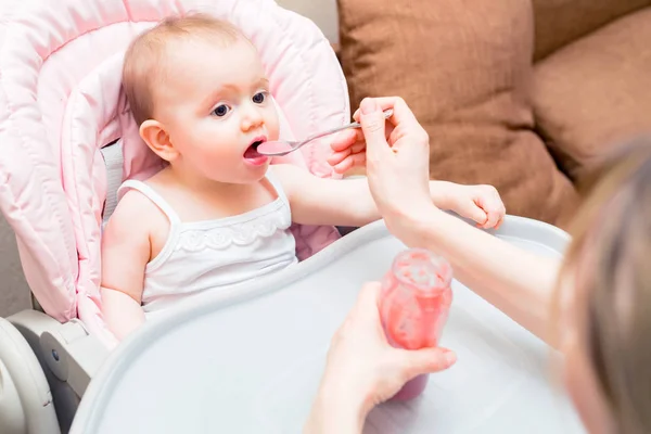 Fütterung niedlichen Baby Mädchen im Kinderwagen mit Löffel — Stockfoto