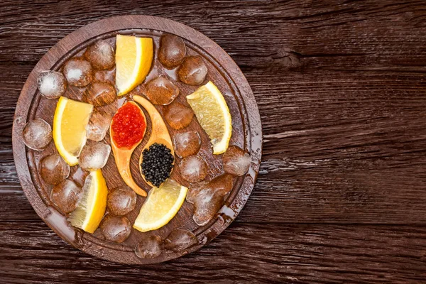 Top view of black surgeon and red salmon caviar on wooden table — Stock Photo, Image