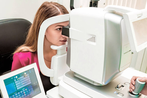 Beautiful woman having an eye lens exam