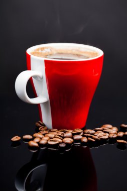 Kırmızı fincan kahve kahve çekirdekleri ve koyu arka plan