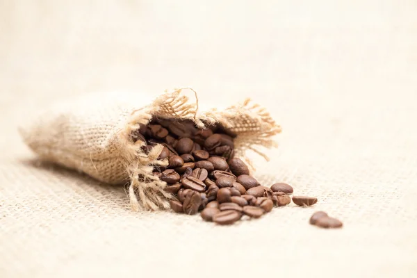 Coffee beans with burlap texture — Stock Photo, Image