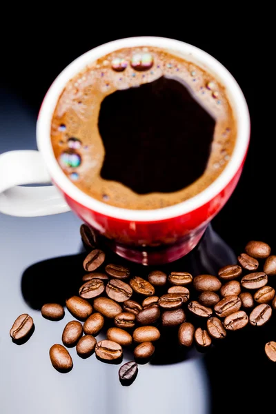 Taza roja de café con granos de café y fondo oscuro — Foto de Stock