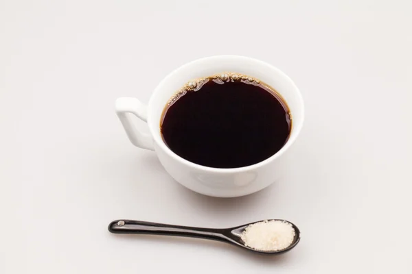 Taza de café blanco con café y cucharadita negra con azúcar morena — Foto de Stock