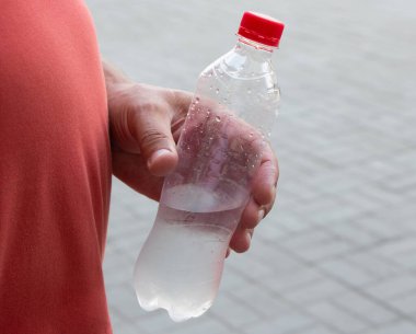 Bir adamın elinde bir şişe su..