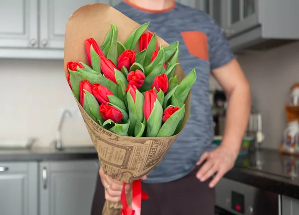 A man holds a bouquet of flowers.