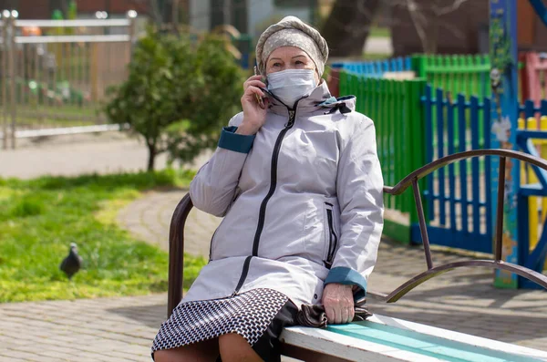 Karantina: Olgun bir kadının yüzünü tıbbi bir maskeyle koronavirüsü, koi-19 veya başka bir virüs türünü önlemek için örterek örtün..