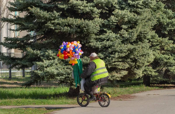 Un hombre lleva globos en una moto . —  Fotos de Stock
