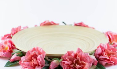 Yapay çiçeklerle süslenmiş ahşap tabak..